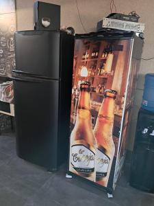 a refrigerator with a picture of three bottles of beer at Casa de festa para festa do peao de barretos in Barretos