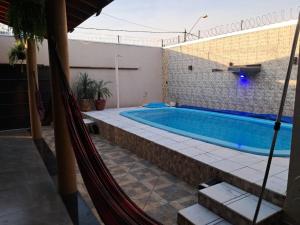 a hammock in front of a house with a pool at Casa de festa para festa do peao de barretos in Barretos