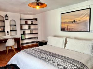 底拉斯卡拉Hotel Boutique Casa Catalá的卧室配有一张壁挂画的床