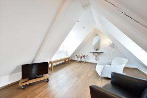 Una sala de estar con televisión y un sofá. en Altstadtapartment Himmelreich, en Heidelberg