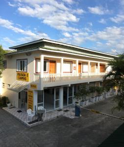 un gran edificio blanco con un cartel delante en Pousada e Camping Lagoa da Conceição en Florianópolis