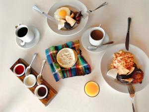 a table with plates of food and cups of coffee at Hotel Cayman Suites in El Garitón