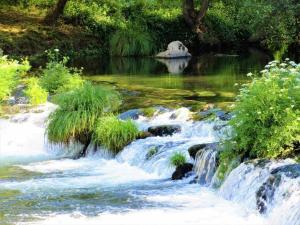 een schilderij van een rivier met een waterval bij Be in Paradise Villa in Esposende