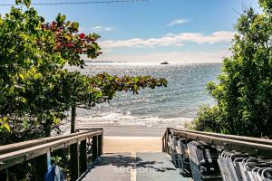 弗洛里亚诺波利斯Resort pé na areia - Suítes JBVTOP的一条通往海滩的小路，有椅子，还有大海
