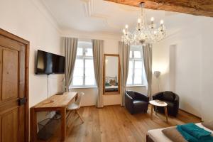 a bedroom with a desk and a bed and a chandelier at Altstadtapartment Bel Etage in Heidelberg