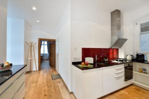 a kitchen with white cabinets and a wooden floor at Altstadtapartment Bel Etage in Heidelberg +11 photos