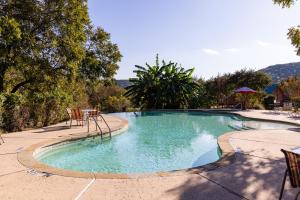 ein großer Swimmingpool mit Stühlen und einem Tisch in der Unterkunft Texas Hill Country Resort in Medina + 26 Fotos