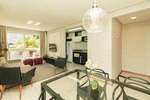 a living room with a glass table and chairs at Apartamento Lindo e Moderno no Centro de Gramado in Gramado