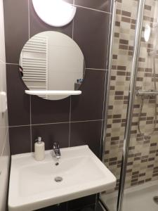 un baño con lavabo y espejo en Apartmán PAULA, en Veľká Lomnica 10 fotos más