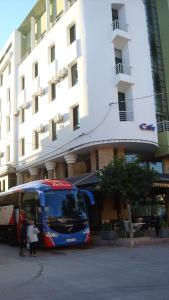 un autobús azul estacionado frente a un edificio en Hôtel Atlas Guercif en Guercif