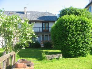 a house with a large bush in the yard at LES GITES D'AVEZE Volcan, Sancy, Bourboule in Avèze