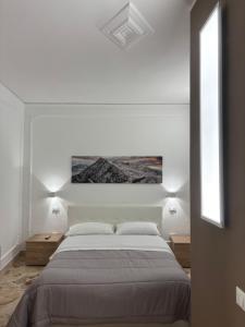 a white bedroom with a large bed and two windows at Appartamento San Vito in Piana degli Albanesi +18 photos