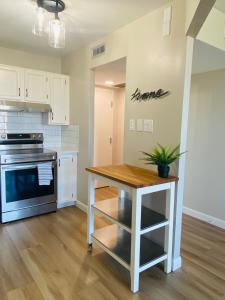 a kitchen with a table and a stove at Contemporary, cozy & easy to Rocky Mountains from Calgary ! in Calgary +3 photos