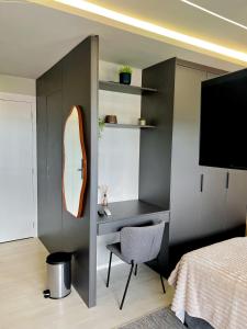 a bedroom with a desk and a bed and a mirror at Modern Studio Brooklin 230 meters from the subway in Sao Paulo