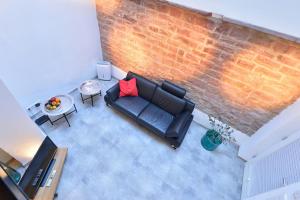 una vista aérea de una sala de estar con sofá y una pared de ladrillo en Altstadtapartment Remise, en Heidelberg
