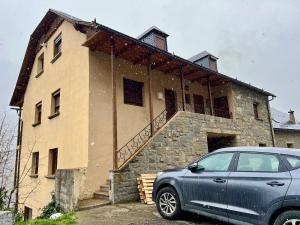a house with a car parked in front of it at Apartamento La Buhardilla del Boscache in San Juan de Plan