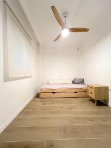 Un dormitorio con una cama y un ventilador de techo. en Apartamento centro Punta Umbría, en Punta Umbría