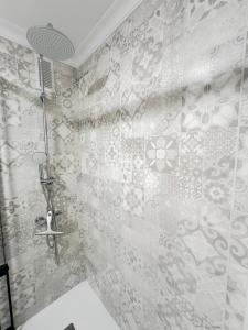 Un baño con ducha con pared de azulejos. en Apartamento centro Punta Umbría, en Punta Umbría 47 fotos más