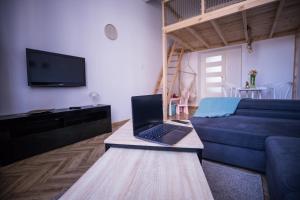 a living room with a couch and a laptop on a table at Apartament Antresola Przemyśl in Przemyśl +33 photos