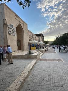 een groep mensen die buiten een gebouw staan bij MUNIS Lyabi hauz in Bukhara