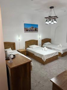 een hotelkamer met twee bedden en een bureau bij MUNIS Lyabi hauz in Bukhara +142 foto's