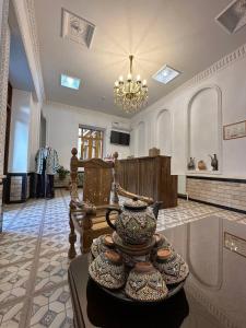 una gran sala de estar con un jarrón sobre una mesa en MUNIS Lyabi hauz, en Bukhara