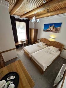 Habitación de hotel con 2 camas, escritorio y sidra de mesa en MUNIS Lyabi hauz, en Bukhara