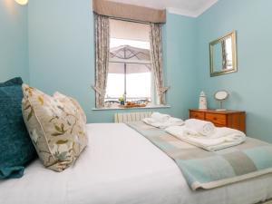 a bedroom with a white bed with a window at Mount View in Marazion