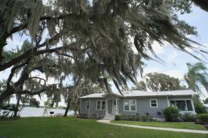 een huis met een grote boom ervoor bij Lakeside Cottages in Lake Placid