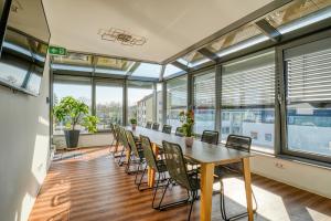 una oficina con mesa y sillas en una habitación con ventanas en Nicetostay Aparthotel, en Bremen