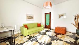 a living room with a green couch and a table at Casa Iolanda in Riposto