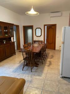 a dining room with a table and a refrigerator at casa rodia in San Pietro in Bevagna