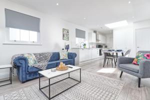 a living room with a blue couch and two chairs and a table at Chelmsford City Centre Modern Duplex With Parking, Wi-Fi & Netflix in Chelmsford +47 photos