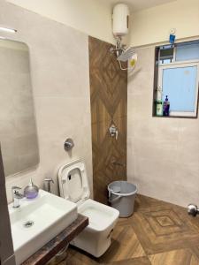 a bathroom with a white toilet and a sink at Your Ultimate Edge Awaits! in Thane