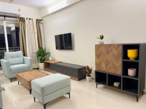 a living room with a tv and a couch and a table at Your Ultimate Edge Awaits! in Thane