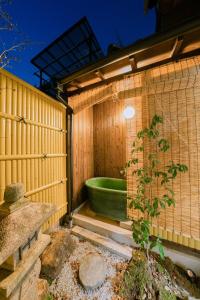 a bathroom with a green tub in a wooden wall at Traditional Japanese architecture heiansya in Kyoto