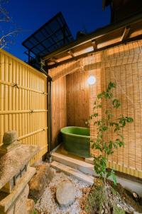 a bathroom with a green tub in a wooden wall at Traditional Japanese architecture heiansya in Kyoto