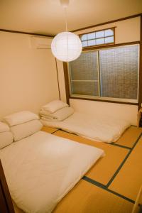 a room with two beds and a large window at Traditional Japanese architecture heiansya in Kyoto +11 photos