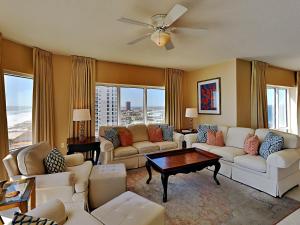 Una sala de estar con muebles blancos y un ventilador de techo. en Emerald Isle #1108 - Emerald Dreams, en Pensacola Beach