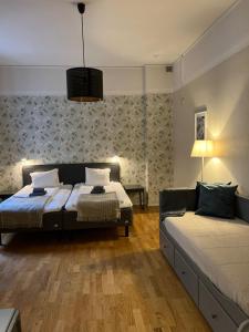a bedroom with two beds and a couch at Hotel Park Allé in Kristianstad