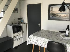 Habitación pequeña con mesa y microondas. en Appartement Achterom, en Hollum 8 fotos más