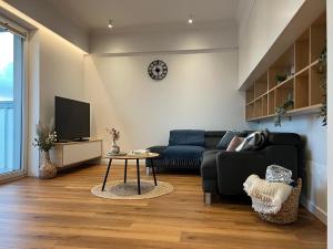 a living room with a black couch and a tv at Luxury Apartment in the City Center - Klimatyzacja, Parking, Balkon, Atlas Arena, Wytwórnia, Piotrkowska in Łódź