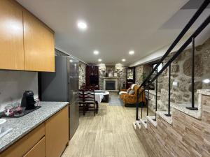a kitchen with a staircase and a living room at Casa Carlinhos da Carreira in Terras de Bouro