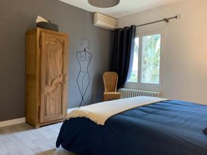 a bedroom with a bed and a dresser and a window at Les Vendanges Maison Vigneronne in Reuilly