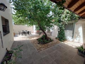 a tree in a courtyard with a table and chairs at La Damasca 1 in General Roca +5 photos