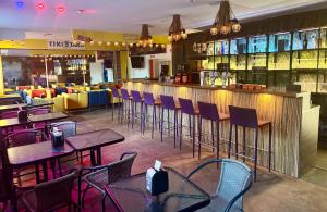 Un bar con sillas y mesas en un restaurante. en Tiki Taka Hostel & Pub, en Vilna