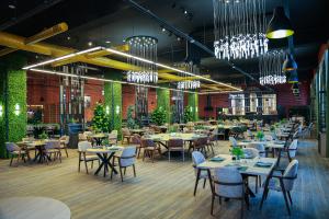 a dining room with tables and chairs and chandeliers at Gabala Bless Hotel Cottage in Gabala
