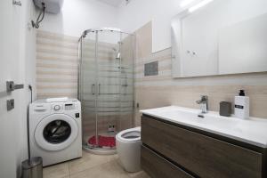 a bathroom with a washing machine and a sink at Donnalucata - 2min dal Mare e AC in Donnalucata