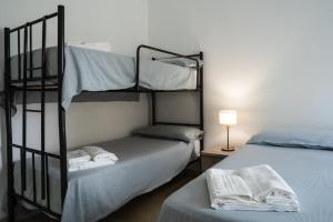 a bedroom with two bunk beds and a lamp at Donnalucata - 2min dal Mare e AC in Donnalucata
