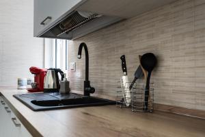 a kitchen counter with a coffee maker and utensils at Donnalucata - 2min dal Mare e AC in Donnalucata +13 photos